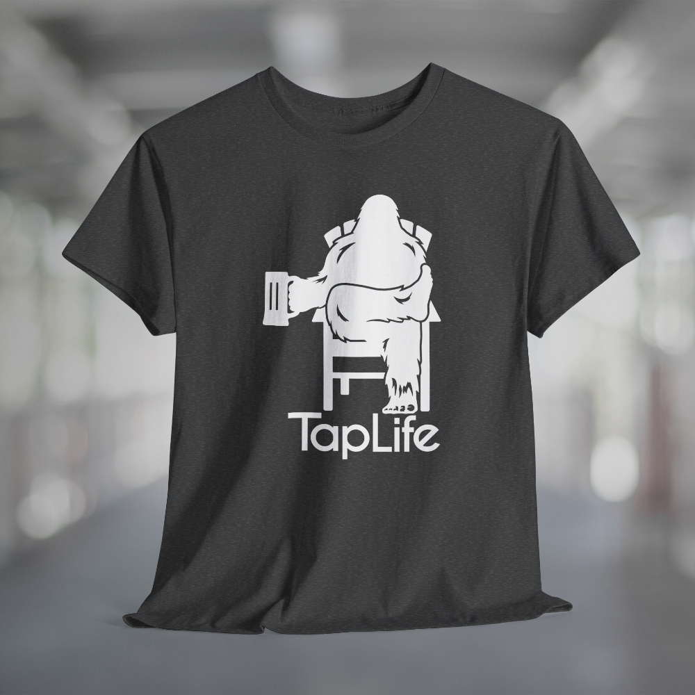 Heather charcoal gray t-shirt with white graphic of Bigfoot holding a beer mug, sitting in a lawn chair with leg crossed in relaxed position, Tap Life logo below.