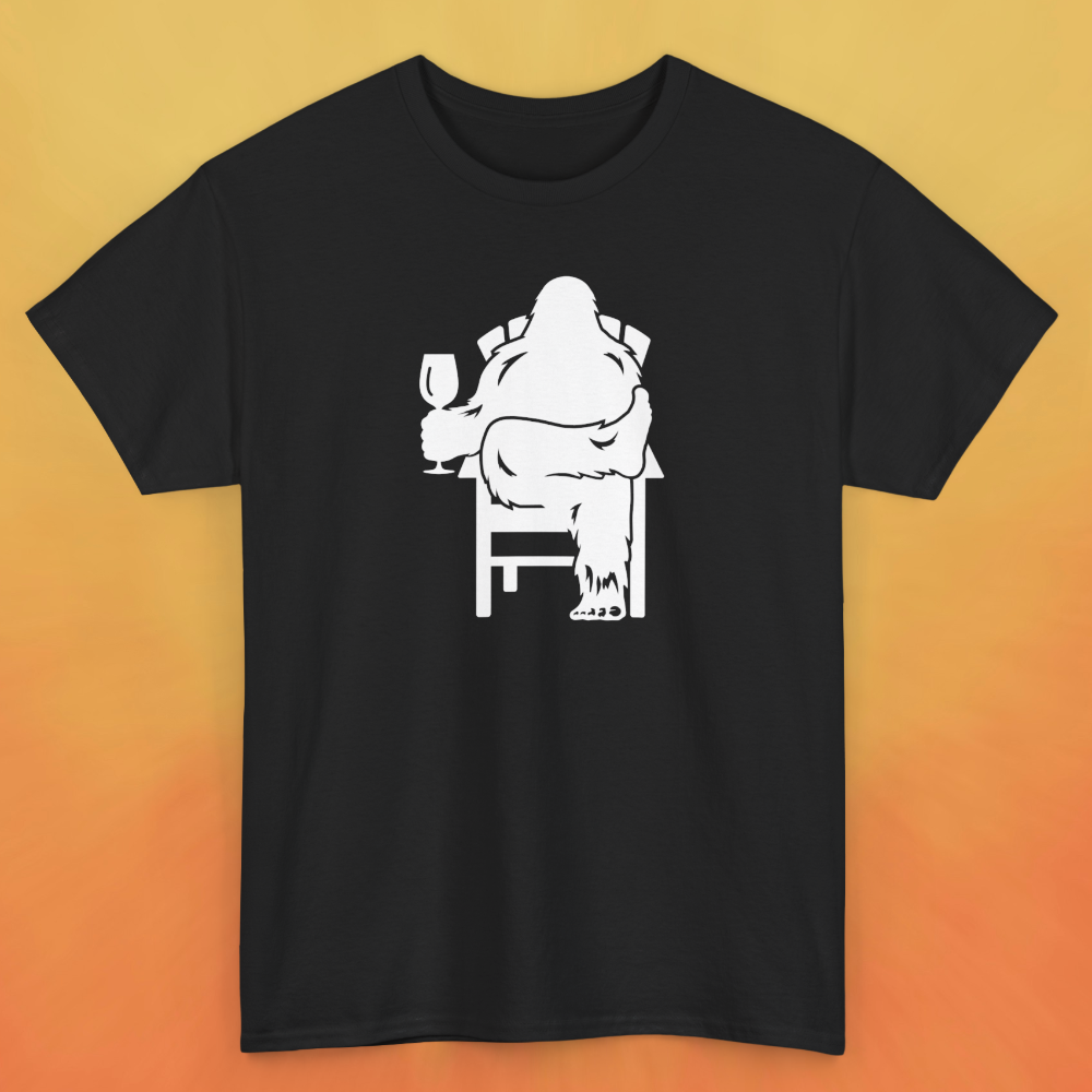 Black t-shirt with white print of Bigfoot relaxing in a chair and enjoying a glass of wine.