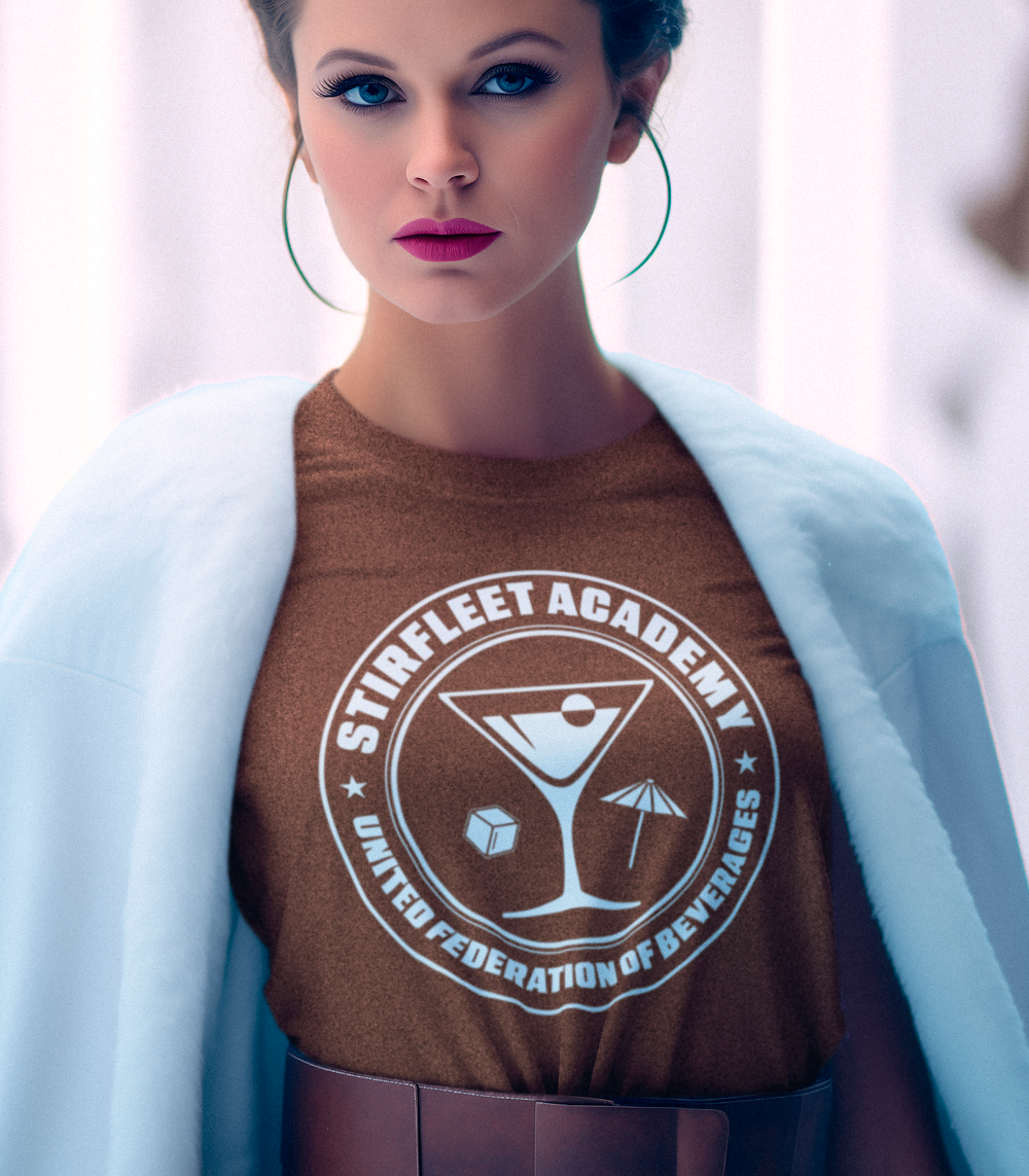 Futuristic woman wearing brown shirt with United Federation of Beverages Stirfleet Academy logo, white graphic design with martini glass, ice cube, and umbrella