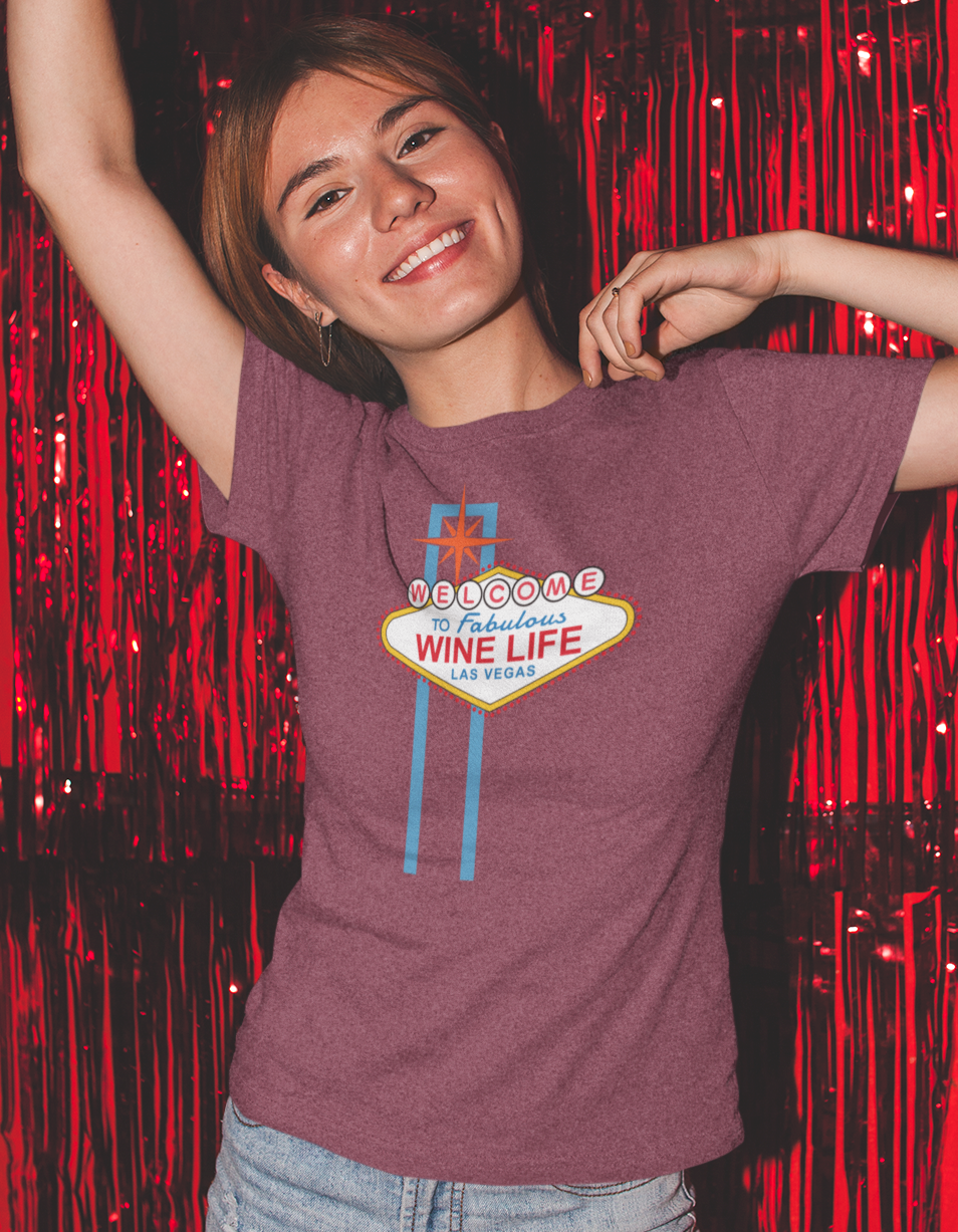 Woman wearing heather red maroon t-shirt, with the welcome to fabulous wine life las vegas sign on front