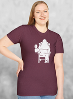 Woman wearing Heather red maroon t-shirt with white print of Bigfoot relaxing in a chair and enjoying a glass of wine.
