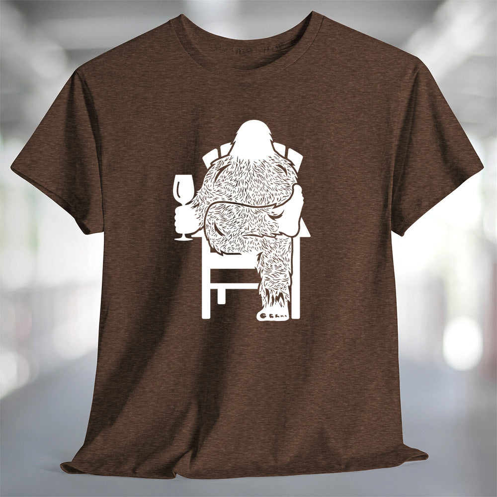 Bigfoot Wine T-Shirt featuring a relaxed Sasquatch holding a wine glass on a brown shirt.