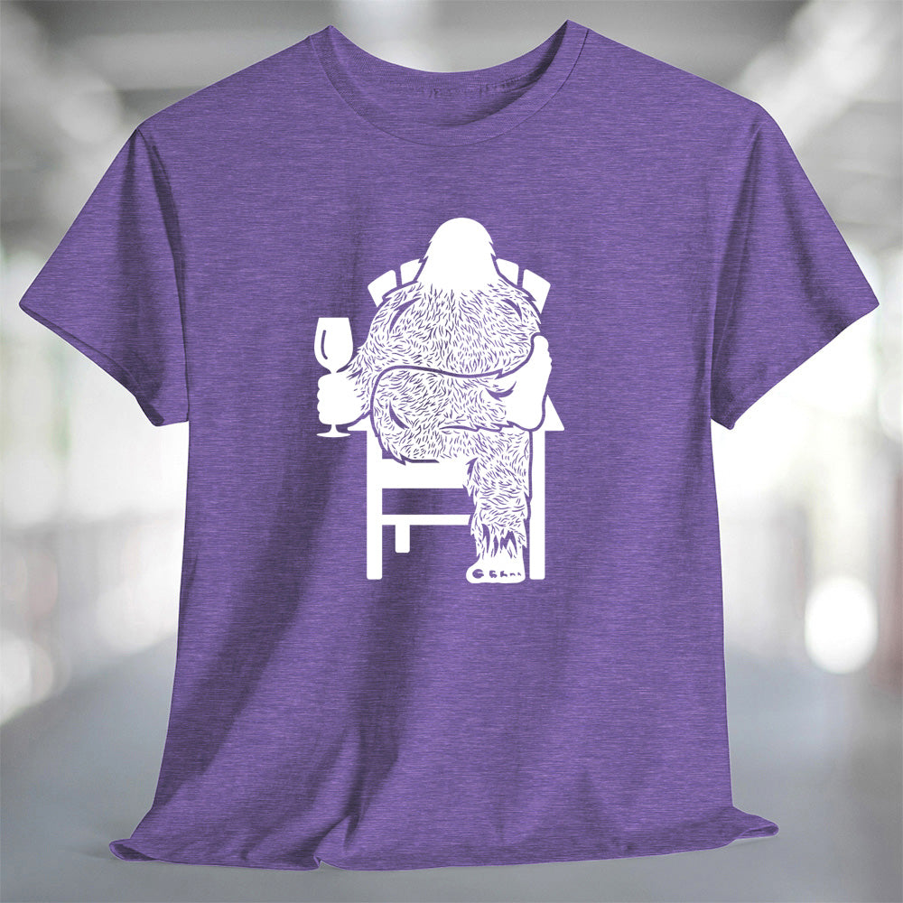Bigfoot Wine T-Shirt featuring a design of Sasquatch relaxing with a glass of wine on a purple t-shirt.