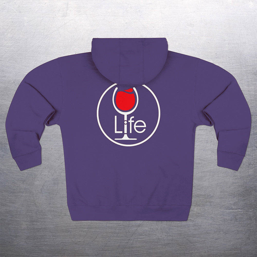 Round "Wine Life" logo with red wine glass on the back of a purple hoodie, on a gray background.