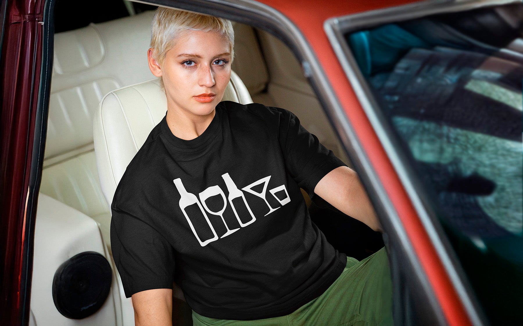 Woman wearing a black t-shirt with stick family figures of wine and beer bottles, and wine glass, martini glass and shot glass