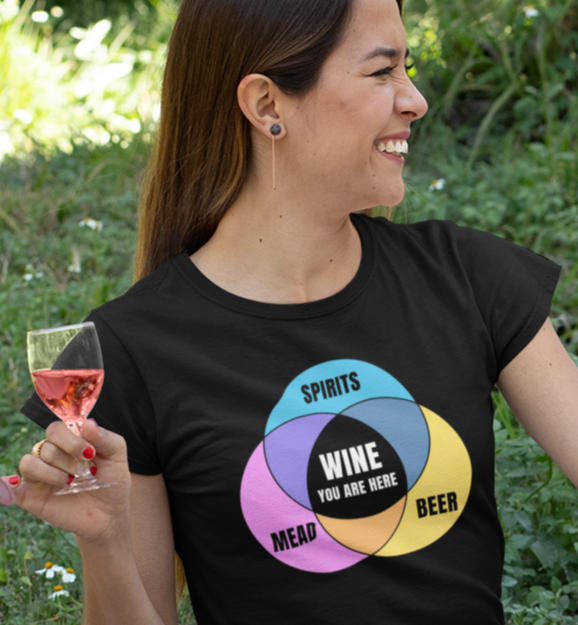 Woman wearing black shirt with colorful graphic Venn  diagram of mead, beer, spirits, and Wine You Are Here in center.