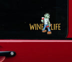 Side window of red truck with sticker decal of cartoon zombie holding wine glass and bottle of wine, with wine life logo in spooky font.