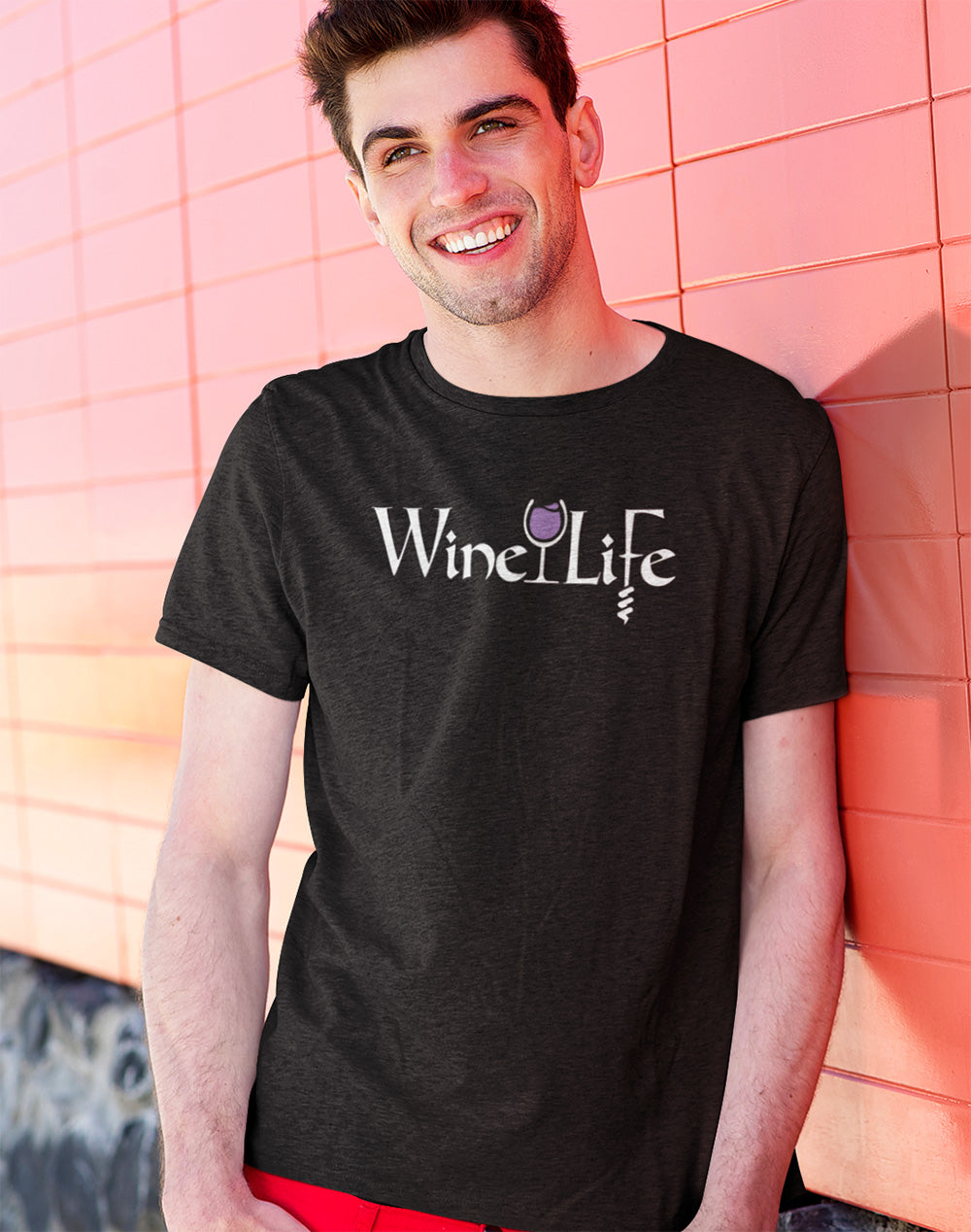 Man wearing Heather charcoal gray t-shirt with Wine Life text written in jagged edge calligraphy letters, with a glass of purple wine and a corkscrew